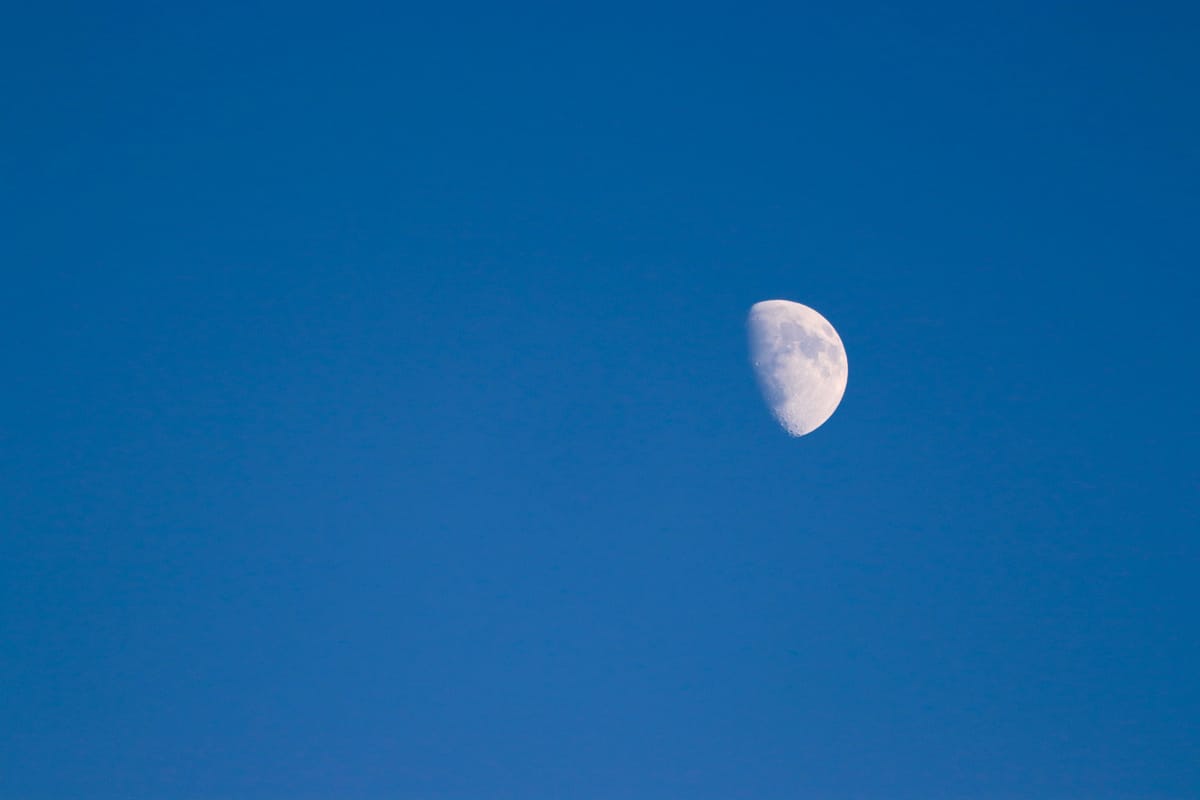 A waxing moon in a clear blue sky