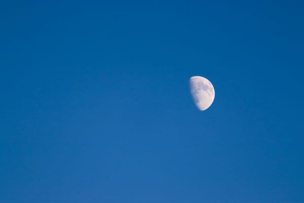 A waxing moon in a clear blue sky